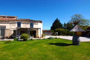 a house with a grass yard in front of a house at Gites PassionPastel in Pech-Luna