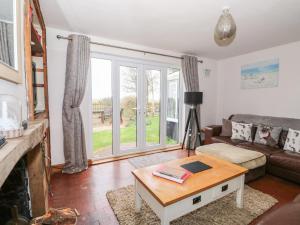 a living room with a couch and a table at Grange Farm Cottage in Sutton Bridge