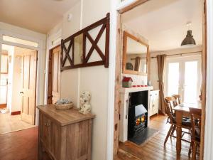 a living room with a fireplace and a table at Grange Farm Cottage in Sutton Bridge