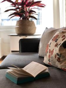 an open book on a couch with a potted plant at Historical Flat, by Zytglogge - 1st Floor in Bern