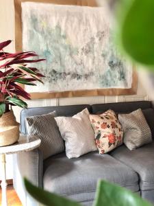 a gray couch with pillows in a living room at Historical Flat, by Zytglogge - 1st Floor in Bern