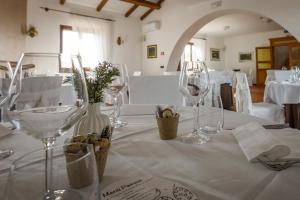 - une table avec des verres à vin sur un tissu de table blanc dans l'établissement Masseria Grande, à Montecilfone