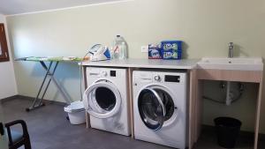 a laundry room with a washing machine and a sink at Hotel Alla Dolina in Sistiana +28 photos