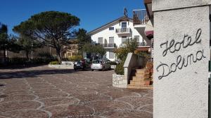 a cobblestone street with cars parked in front of a building at Hotel Alla Dolina in Sistiana