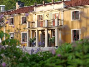 卡特琳娜霍尔姆杜夫维霍勒姆斯乡村酒店的一座黄色的大建筑,设有门廊和阳台