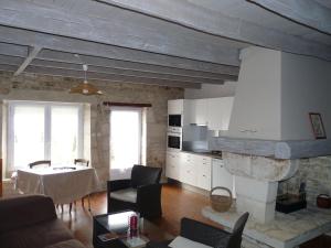 - un salon avec une cheminée en pierre et une table dans l'établissement Le Relais de Chavagné, à Chauray
