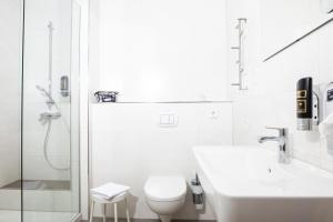 a bathroom with a shower and a toilet and a sink at Hotel Haus Nachtigall - B&B in Uedem +60 photos