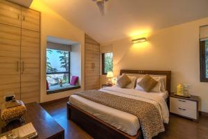 a bedroom with a large bed and a window at StayVista at Cottage in the Clouds with Heater & Bonfire in Mussoorie