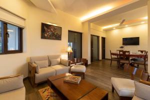 a living room with a couch and a table at StayVista at Cottage in the Clouds with Heater & Bonfire in Mussoorie