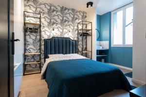 a blue bedroom with a bed with a blue headboard at The Design Shelter - Duke Housing in Vitry-sur-Seine