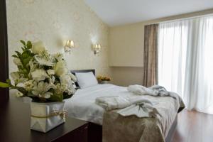 a bedroom with a bed with a vase of flowers at MariaLuis Hotel in Tbilisi City