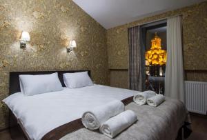 a bedroom with a large bed with towels on it at MariaLuis Hotel in Tbilisi City