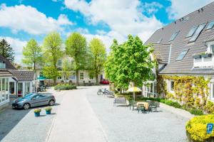 eine Straße in einer Stadt mit Häusern und Auto in der Unterkunft HofHotel Krähenberg in Grömitz