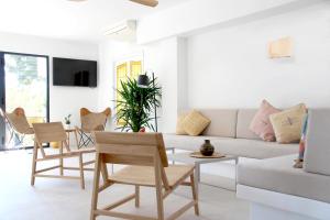 - un salon avec un canapé blanc et des chaises dans l'établissement Aparthotel Niu d´Aus, à Portopetro