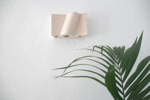 a light on a wall next to a plant at Aparthotel Niu d´Aus in Portopetro