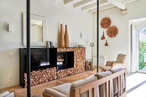 ein Wohnzimmer mit einem Kamin und einem TV in der Unterkunft Quinta do Porto Nogueira by Romana Vini in Alguber