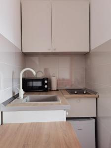 a kitchen with a sink and a microwave at Apartman Krasula Doboj in Doboj