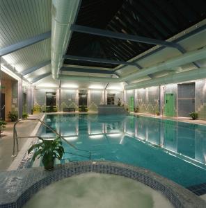 a large indoor swimming pool with a large tub at Elfordleigh Hotel in Plymouth