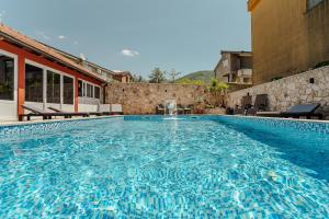 a large swimming pool with blue water in a building at Guest House Villa Živanović in Herceg-Novi