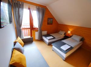 a small room with two beds and a window at Zajazd PTTK Pod Roztoką in Rytro