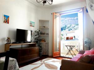 a living room with a tv and a large window at Bellevue in Nice