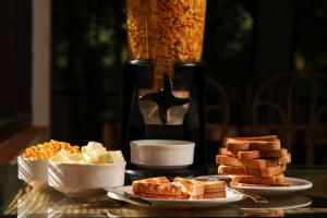 a table topped with plates of bread and toast at Agraharam Resorts in Thirunelli