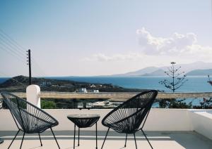 two chairs and a table on a patio overlooking the ocean at Heyblue Aura Seaside Villa - Unique escape in Naxos Chora