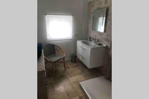a bathroom with a sink and a chair and a mirror at Au coeur de la Toscane Angevine in Chaudefonds-sur-Layon