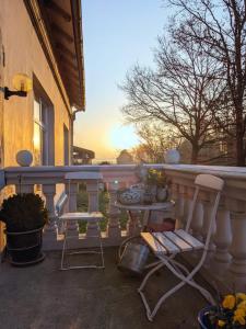 un porche con 2 sillas y una mesa en el balcón en Farm stay Hof auf der Wurp, en Harrierwurp
