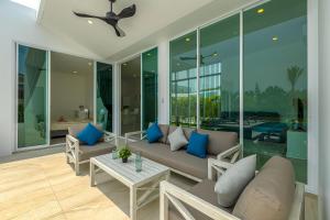 a living room with a couch and a table at Modern 3 Bedroom Private Pool Villa PMK-A1 in Khao Tao