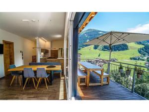 a kitchen and dining room with a table and an umbrella at All.Glemm SKY SUITE in Saalbach Hinterglemm