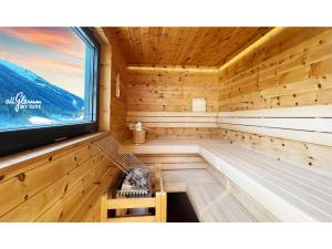 a wooden sauna with a window and a tv at All.Glemm SKY SUITE in Saalbach Hinterglemm