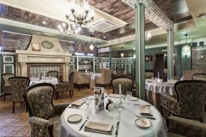 a restaurant with tables and chairs and a fireplace at Hotel Megapolis in Bryansk