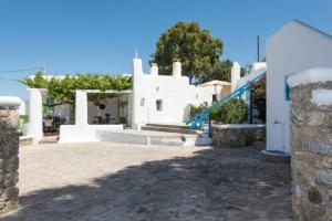 a house with white walls and a staircase in a yard at Casa Annaise Mykonos - Cycladic House with Jacuzzi in Mikonos