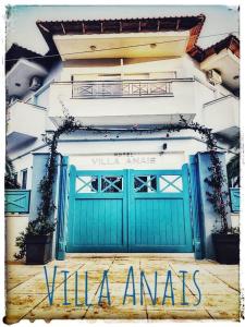 a building with a green garage door with the words villa amaris at Hotel Villa Anais in Prinos
