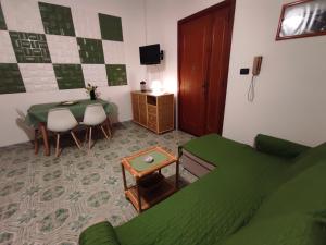 a living room with a table and a green bed at I colori di Otranto by CASASI Vacanze Otranto in Otranto