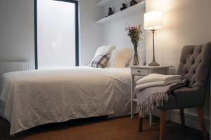1 dormitorio con 1 cama, 1 silla y 1 lámpara en Downshire Haven en Holywood