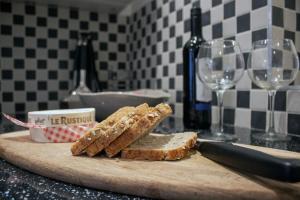 a cutting board with bread and two glasses of wine at Downshire Haven in Holywood