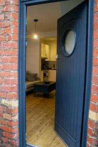 een blauwe deur die leidt naar een woonkamer met een bank bij Downshire Haven in Holywood