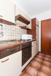 una cocina con estufa y microondas en Ferienhaus Grodehus, en Dornumergrode