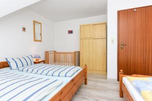 1 Schlafzimmer mit 2 Betten und einer Holztür in der Unterkunft Ferienhaus Grodehus in Dornumergrode