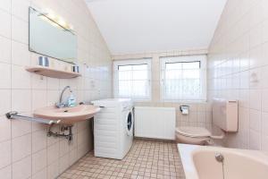 Un baño blanco con lavabo e inodoro. en Ferienhaus Grodehus, en Dornumergrode 23 fotos más