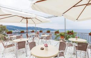 un patio con tavoli, sedie e ombrelloni di Baia Serena a Vico Equense