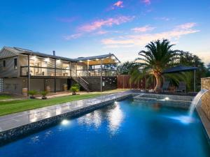 a house with a swimming pool in front of a house at Lilies on Lovedale Estate - Heated Pool and Spa in Lovedale