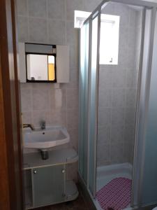 uma casa de banho com um lavatório e uma cabina de duche. em Studio Jasna em Brzac