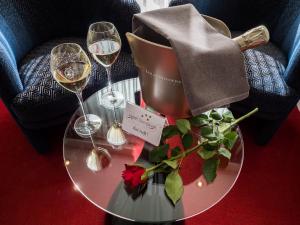 a table with two wine glasses and a bouquet of flowers at Best Western Hotel Slenaken in Slenaken