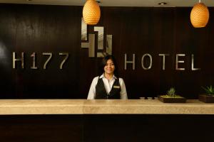 a woman sitting at a counter in a hotel at H177 Hotel in Campeche