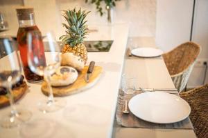 un tavolo con bicchieri, piatti e un ananas sopra di Jable suites apartamentos de lujo en el centro a Corralejo
