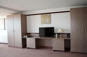 an office with a desk with a television on it at Leipziger Hotel in Leipzig