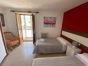 a bedroom with a bed and a red wall at El Puente in Boltaña